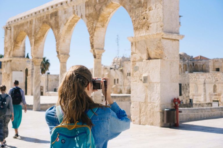 a person taking a picture of a large stone building