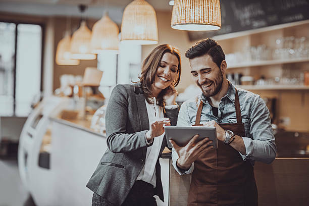 a man and a woman looking at a tablet