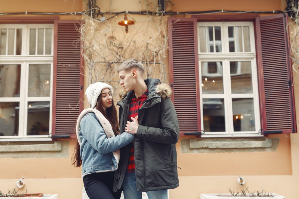 a man and woman hugging in front of a building